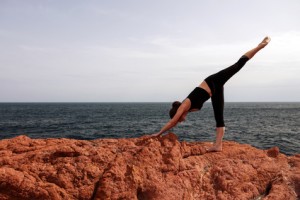 Young woman doing yoga flexibility on the rocks