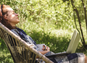 femme qui lit dans un fauteuil dehors